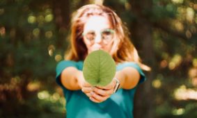 Una donna con una foglia in mano per l'ambiente