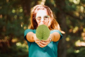 Una donna con una foglia in mano per l'ambiente